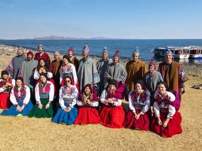 Groepsfoto aan het Titicacameer in traditionele kleding, Route Peru dag 13.