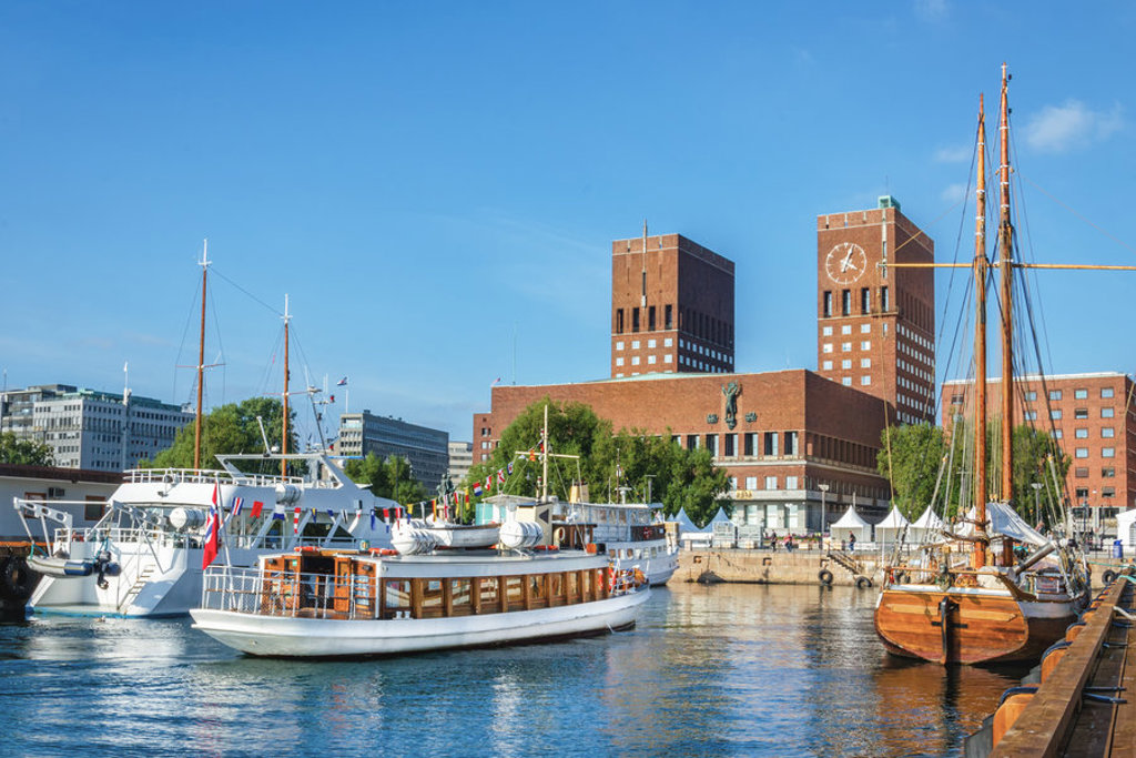 Haven van Oslo met boten en het stadhuis op de achtergrond, vertrekpunt voor zeilschip Antigua naar Spitsbergen.