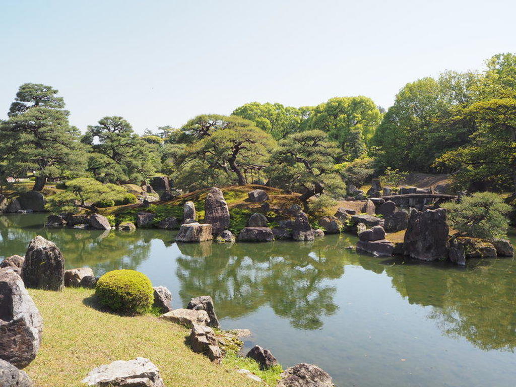 Japanse tuin met vijver, rotsen en dennenbomen tijdens een groepsrondreis Japan.