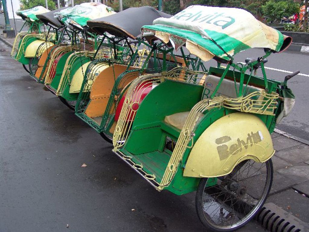 Rij kleurrijke fietstaxi’s (becaks) op straat tijdens groepsrondreis Java & Bali.