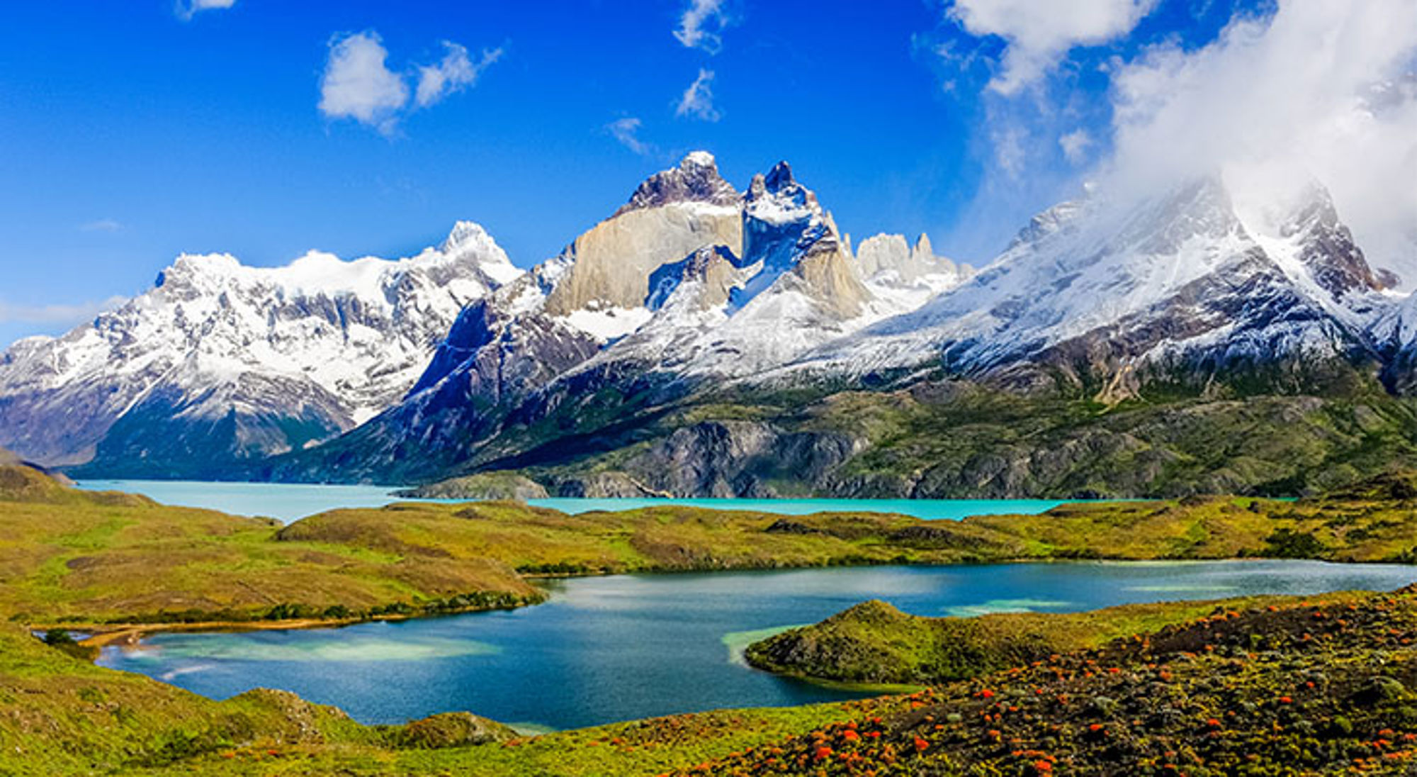 Kronkelend meer in het Nationaal Park Torres de Paine Besneeuwde bergtoppen en turquoise meren in Patagonië onder een heldere blauwe lucht.