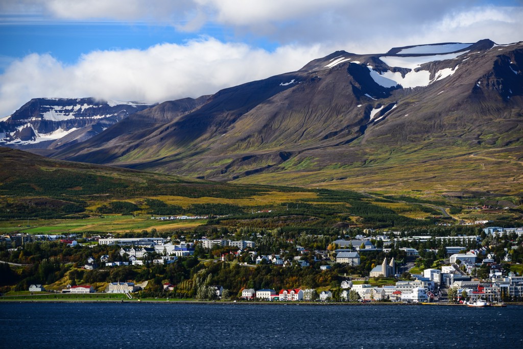 Uitzicht op Akureyri met fjord en bergen met sneeuwvelden, tijdens groepsrondreis IJsland kamperen.