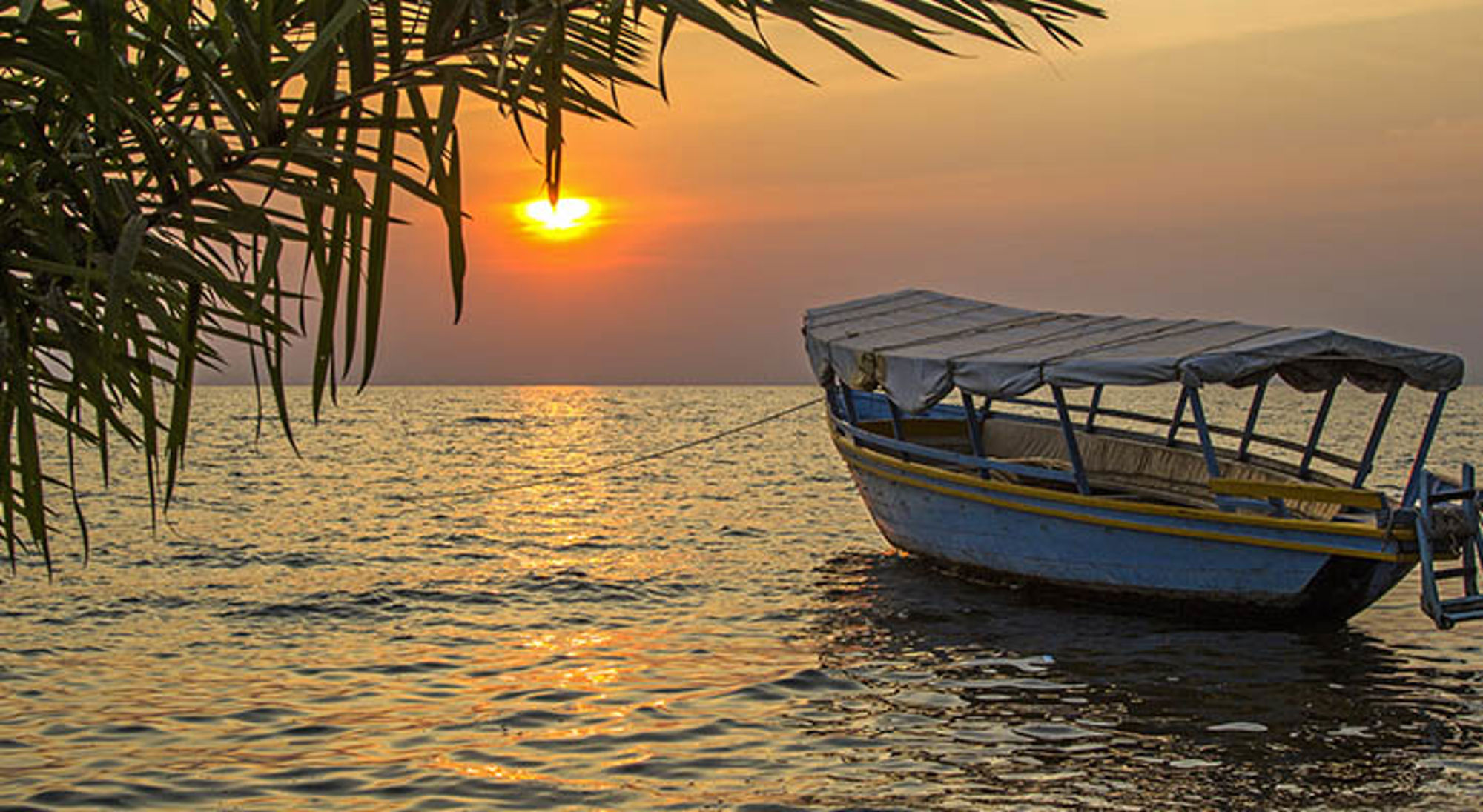 Boot op zee bij zonsondergang aan de kust van Tanzania.