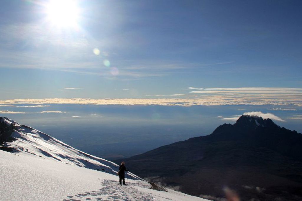 Wandelaar in de sneeuw op de Kilimanjaro tijdens een wandelvakantie in Tanzania.