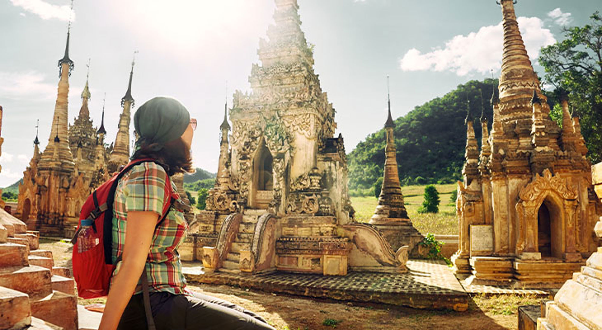 Bagan Myanmar Rugzaktoerist bekijkt oude pagodes en tempelruïnes in een zonovergoten landschap.