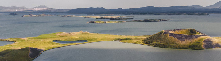 Uitzicht over het Mývatn-meer met groene schiereilanden en vulkanische kraters in Noord-IJsland.