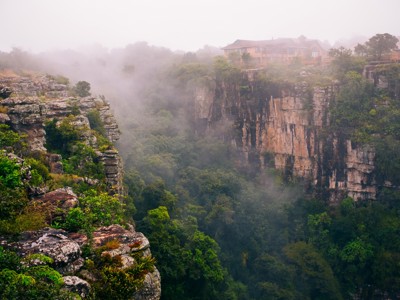 Mistige kloof met steile rotswanden en groen bos, Route Zuid-Afrika.