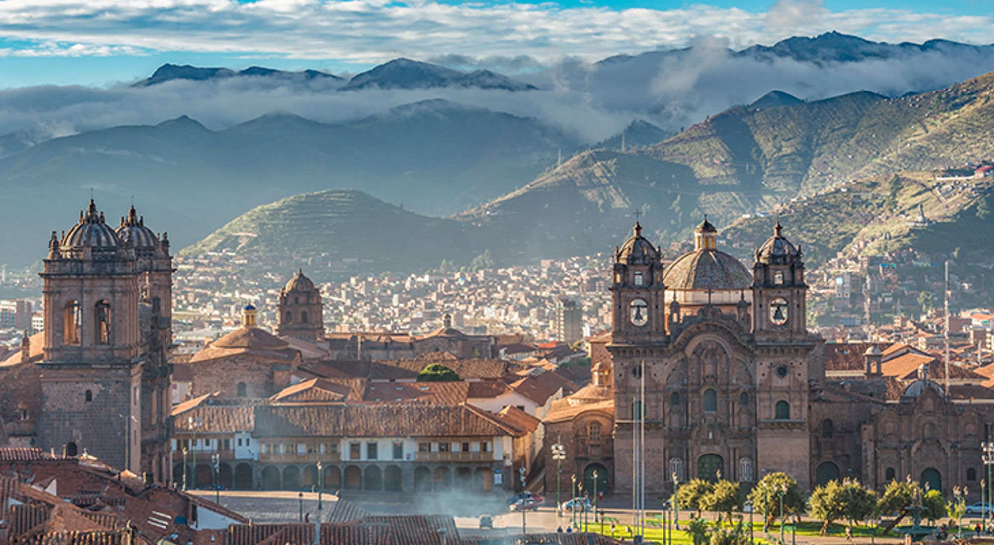 Panoramisch uitzicht op Cusco met de kathedraal en bergen op de achtergrond.