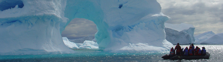 Zodiacboot met reizigers langs ijsbergen in Antarctica tijdens een groepsrondreis.