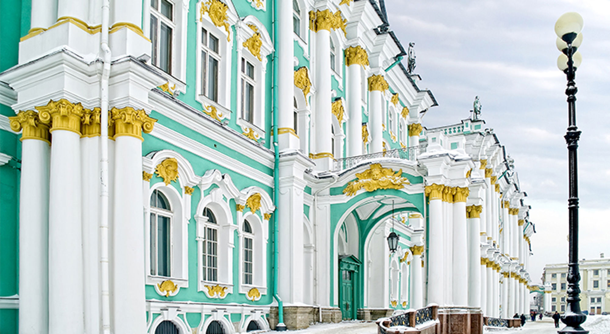 Gevel van het Winterpaleis in Sint-Petersburg met groen-witte zuilen en gouden ornamenten.