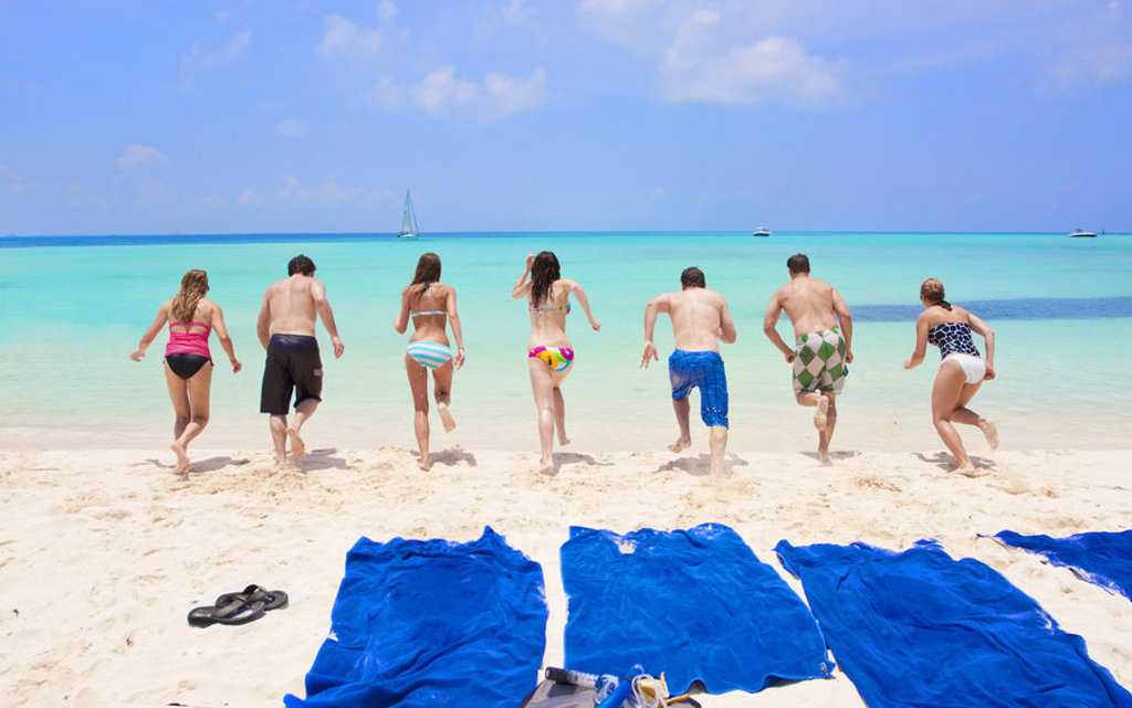 Jongeren rennen vanaf het strand de zee in tijdens een 22-35ers reis Mexico.