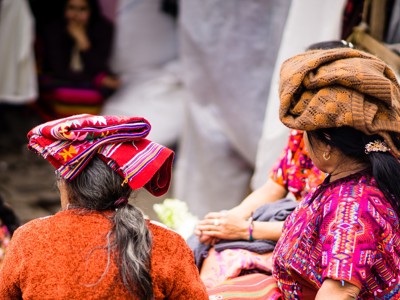 Vrouwen in kleurrijke traditionele kleding op een markt in Guatemala tijdens de Route Guatemala, 21 dagen.