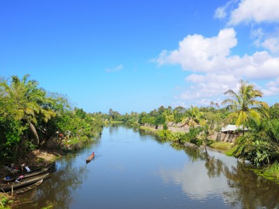 Kanaal met houten kano’s langs tropische begroeiing en dorpjes tijdens Route Madagascar, 19 dagen.