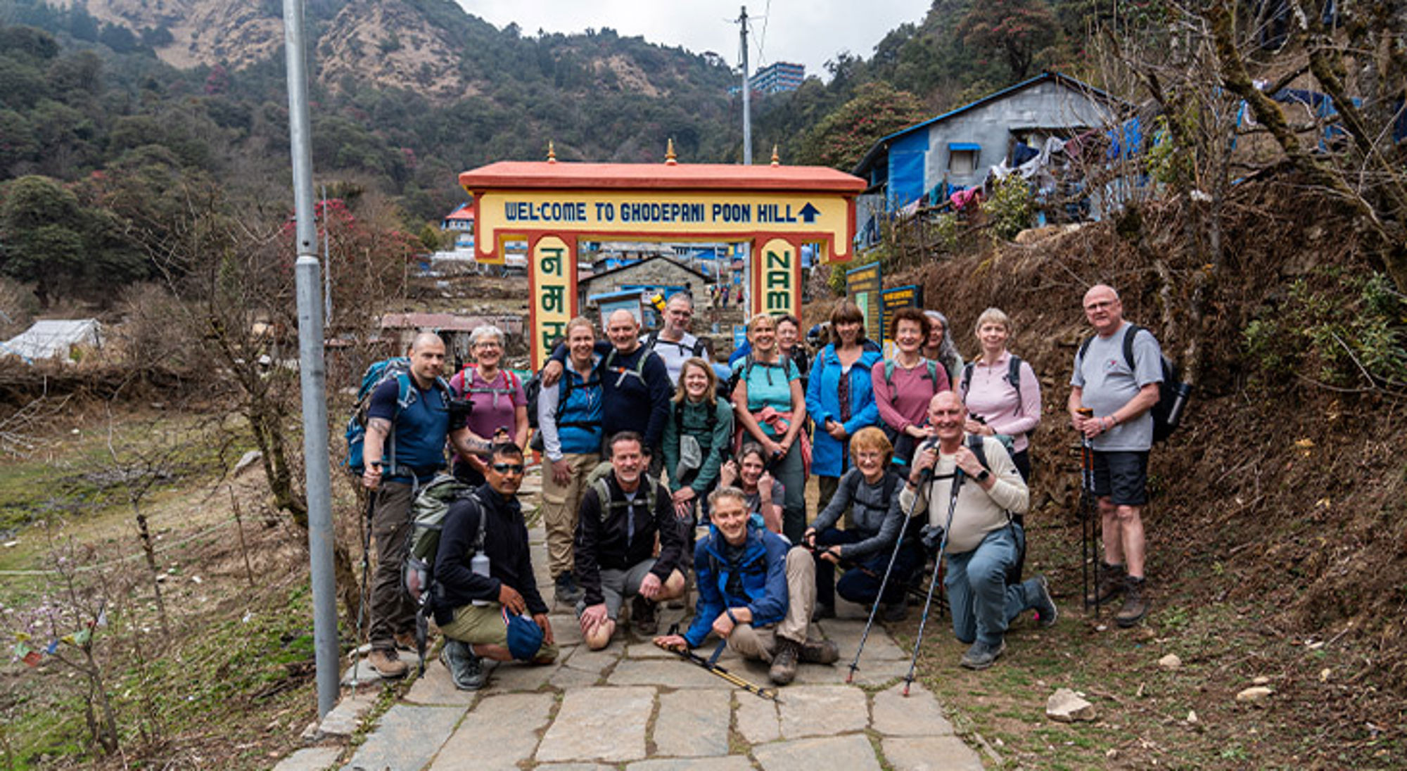 Ghorepani Poon Hill trekking Nepal Wandelaars poseren bij de poort “Welcome to Ghodepani Poon Hill” tijdens een trekking in Nepal.