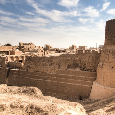 Leemstenen stadsmuur met ronde toren in Yazd tijdens een dagexcursie.