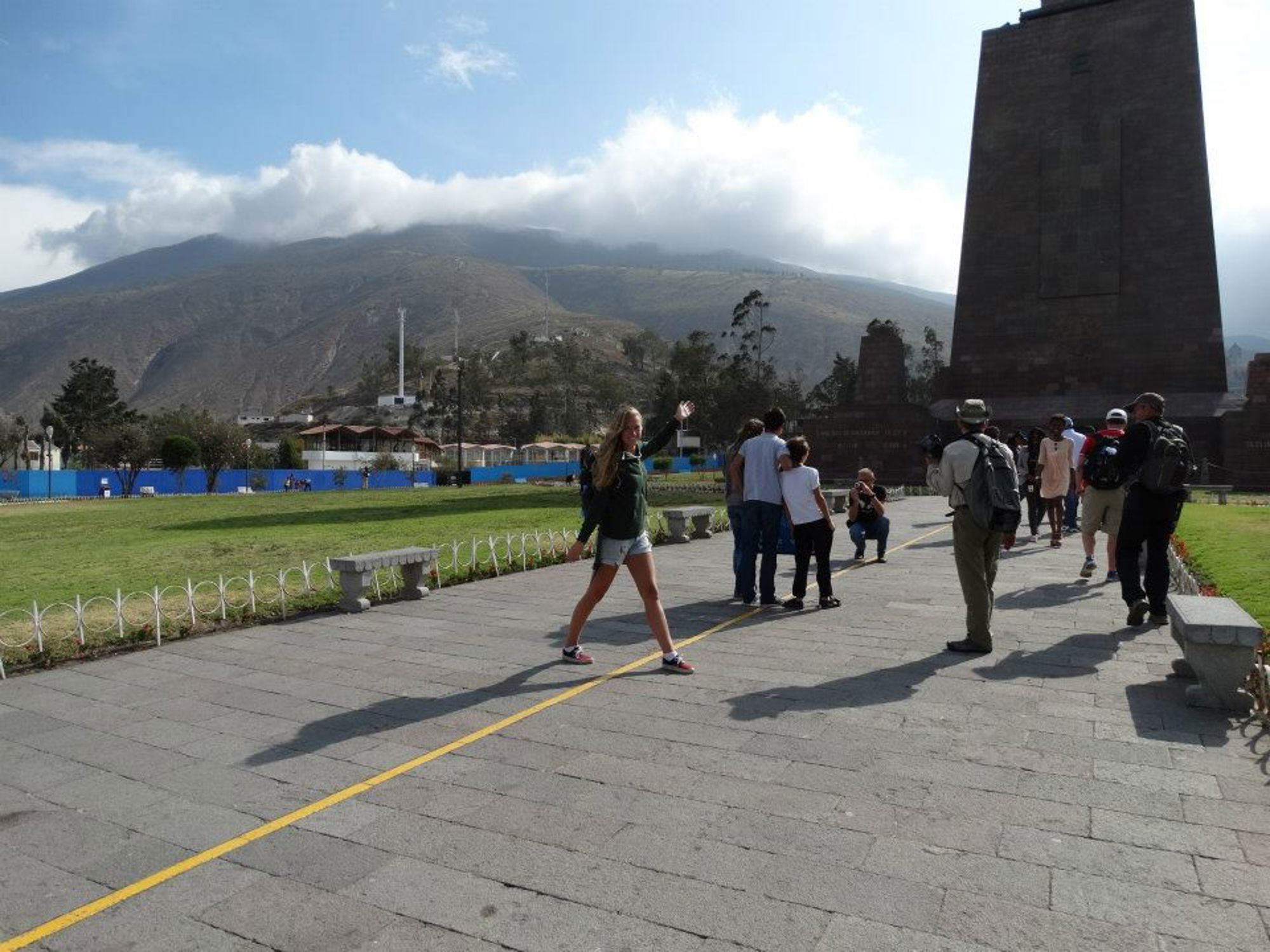 Quito, Ecuador Toeristen bij de evenaarlijn bij Mitad del Mundo, met bergen op de achtergrond.