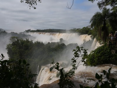 Uitzicht op de Iguazú-watervallen in Argentinië, met nevel boven het regenwoud en een uitkijkplatform.