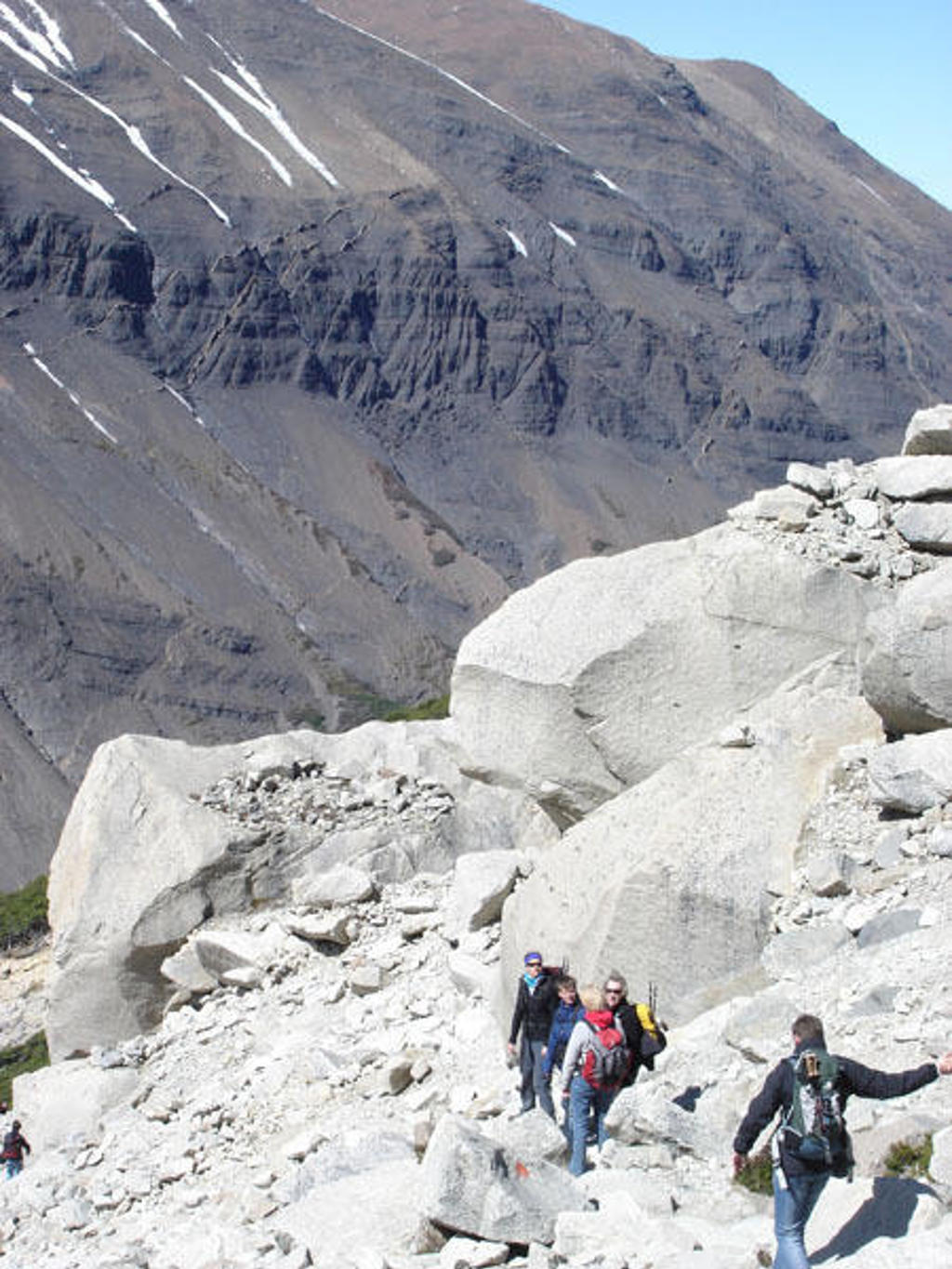 Wandelaars tussen rotsblokken in de bergen van Patagonië tijdens de groepsrondreis Patagonië Hoogtepunten.