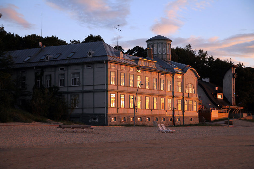 Historisch houten strandgebouw bij zonsondergang tijdens familiereis Polen en Baltische Staten.