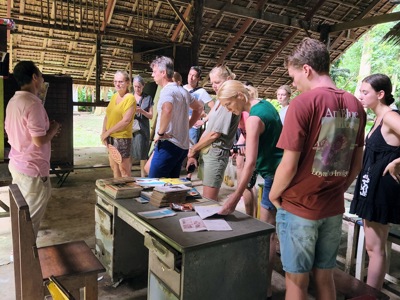 Reizigers luisteren naar uitleg tijdens een bezoek aan een lokaal project in Thailand, Route Thailand dag 7.