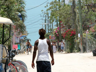Man loopt over zonnige straat richting zee langs de Pan-American Highway route door Midden-Amerika.