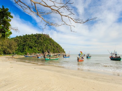 Vissersboten voor de kust bij een groen eiland in Thailand, tijdens de rondreis Thailand Avontuur 24 dagen.
