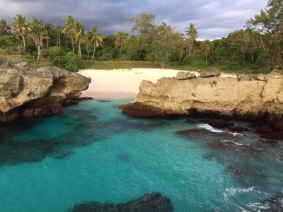 Tropisch strand met turquoise zee, rotsen en palmbomen op Sumba tijdens de route Timor, Sumba & Bali.