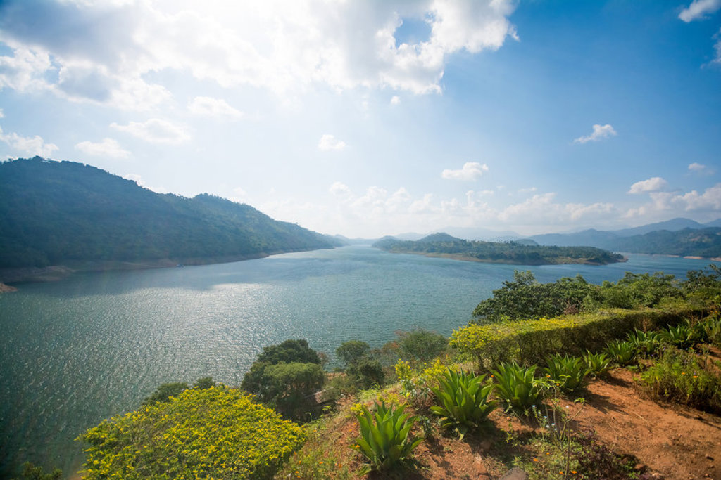 Uitzicht over een groot stuwmeer tussen groene bergen in Sri Lanka, bij de hoogtepunten van een familiereis.