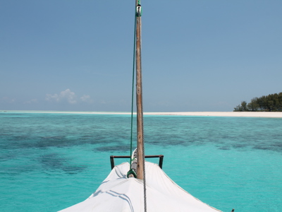 Dhow op turquoise zee bij wit strand van Zanzibar tijdens route Kenia, Tanzania en Zanzibar.