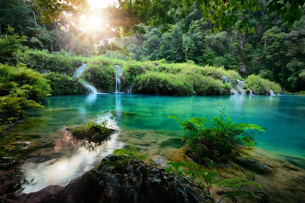 Groenblauwe lagune met kleine watervallen in het regenwoud tijdens een groepsrondreis Guatemala en Copán.