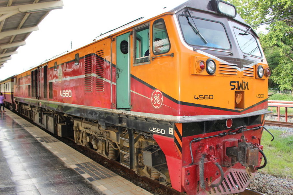 Oranje-rode trein op een station in Thailand tijdens de groepsrondreis Thailand Noord en Zuid Hoogtepunten.
