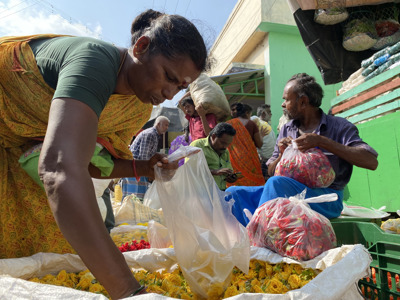 Bloemenmarkt in Zuid-India met verkopers die zakken met rozen en gele bloemen vullen.