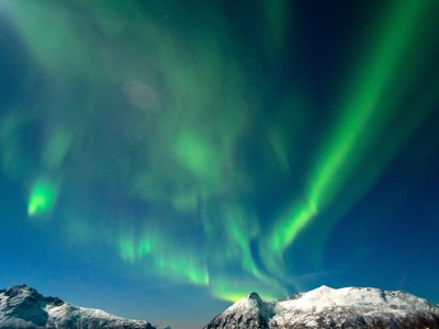 Noorderlicht boven besneeuwde bergen in Noord-Noorwegen tijdens de zeilreis met de Antigua.