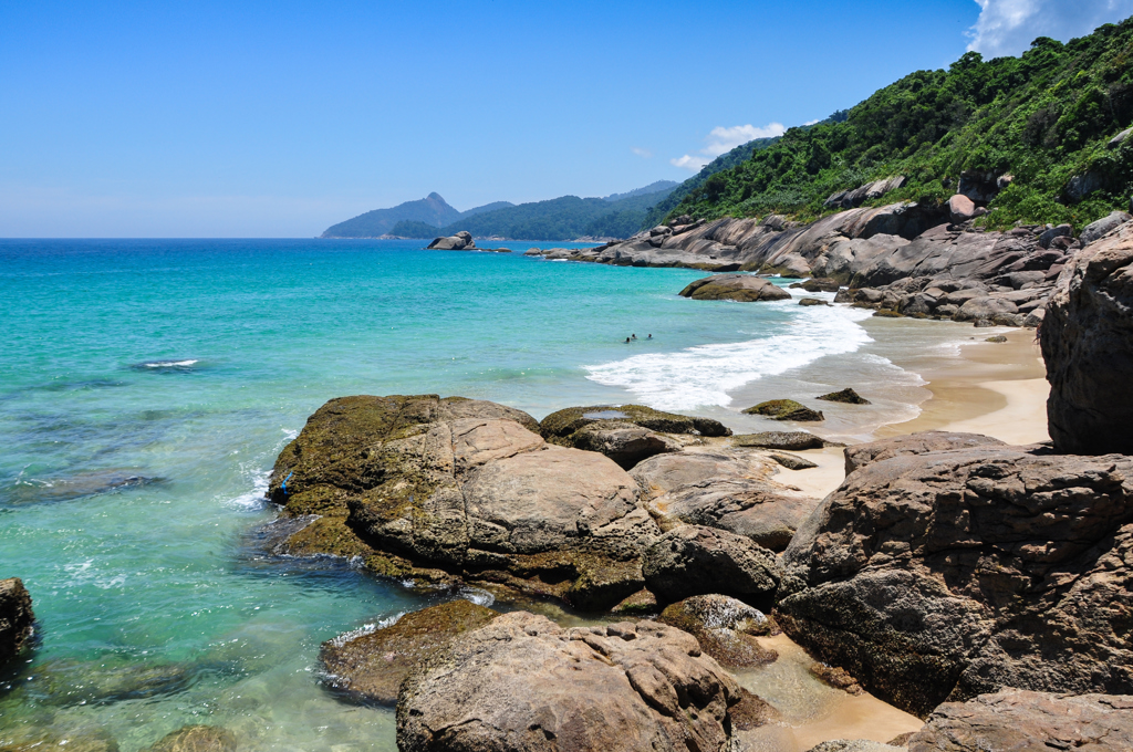 Rotsachtig strand met turquoise zee en groene heuvels aan de kust van Brazilië tijdens familiereis Argentinië en Brazilië.