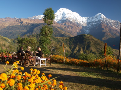 Reizigers ontbijten op terras met uitzicht op de besneeuwde Annapurna in Nepal.