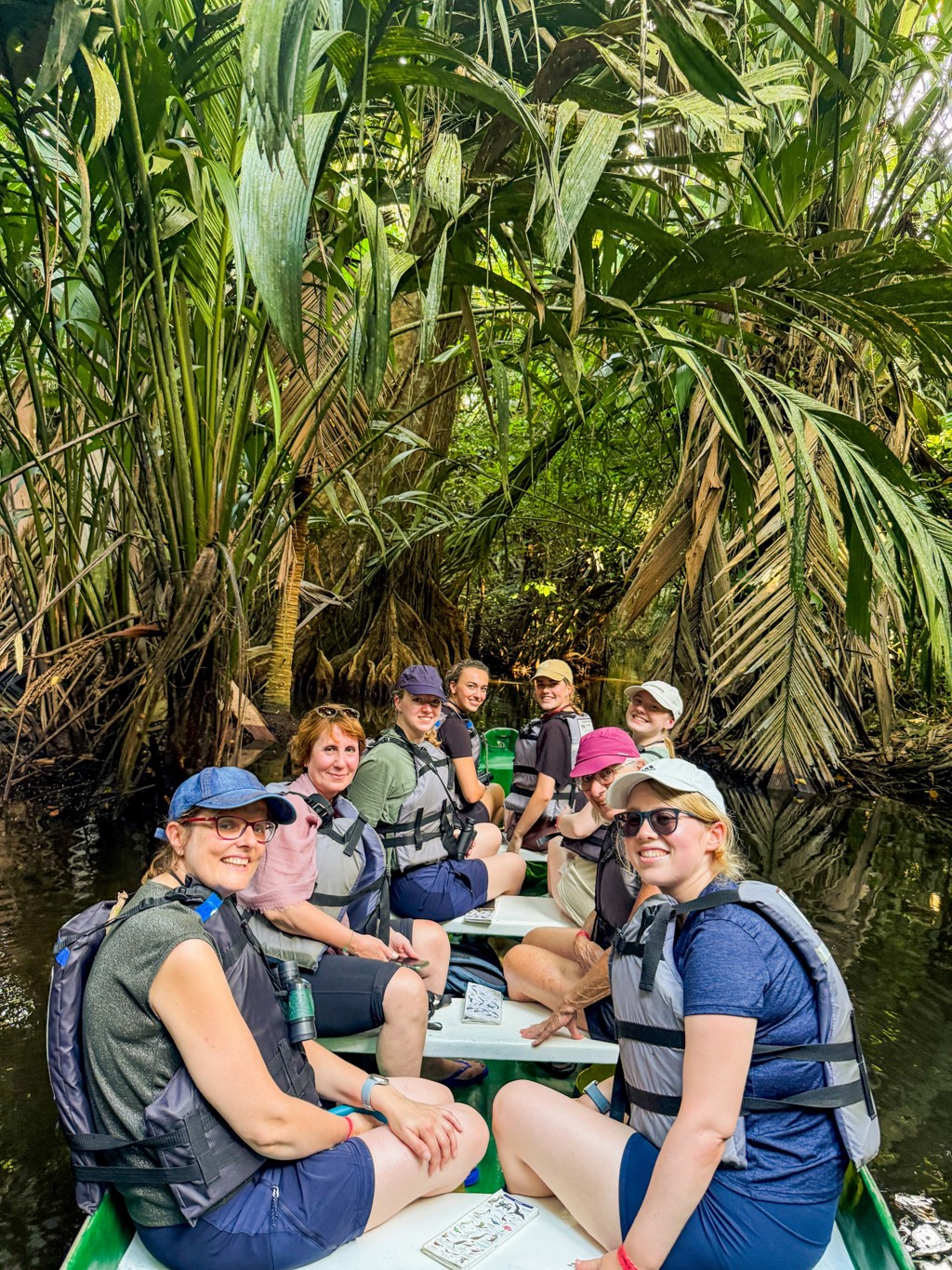 Groepsrondreis Costa Rica: reizigers in boot met reddingsvesten door tropisch regenwoudkanaal.