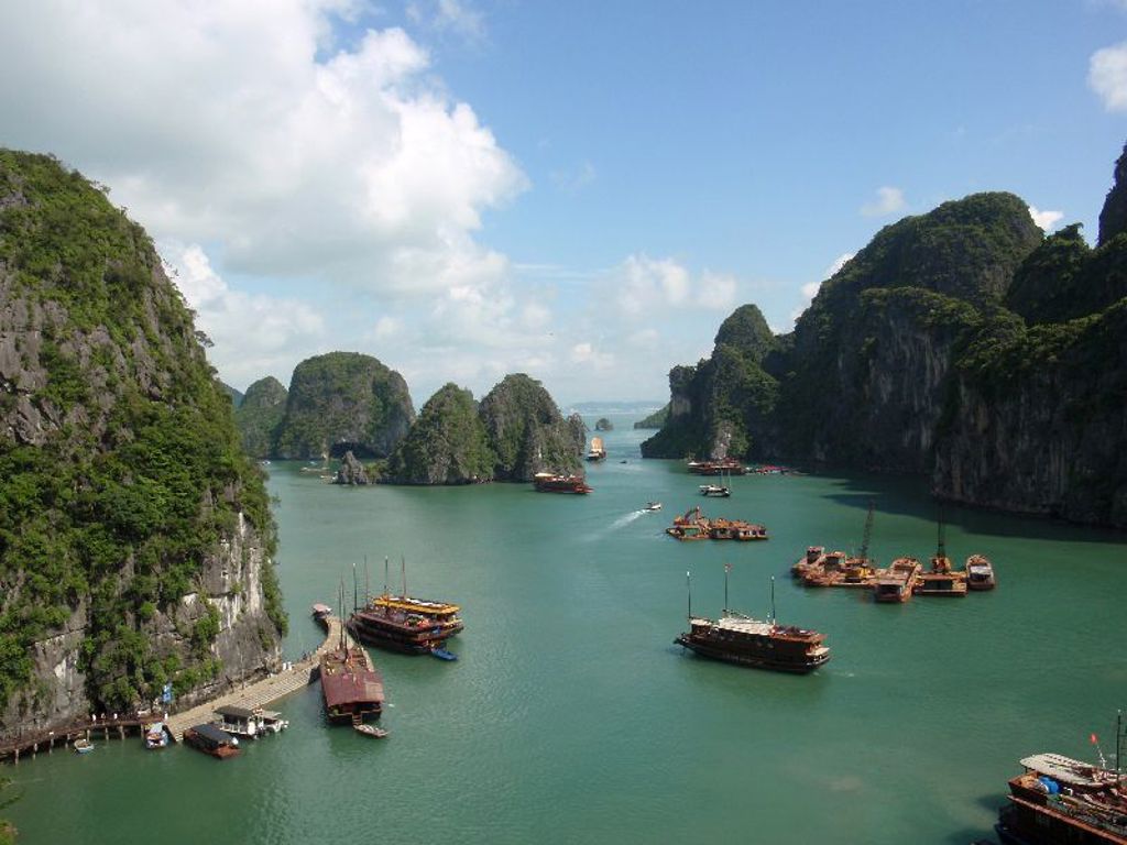 Uitzicht op Halong Bay in Vietnam met kalkstenen rotsformaties en boten op turquoise water.
