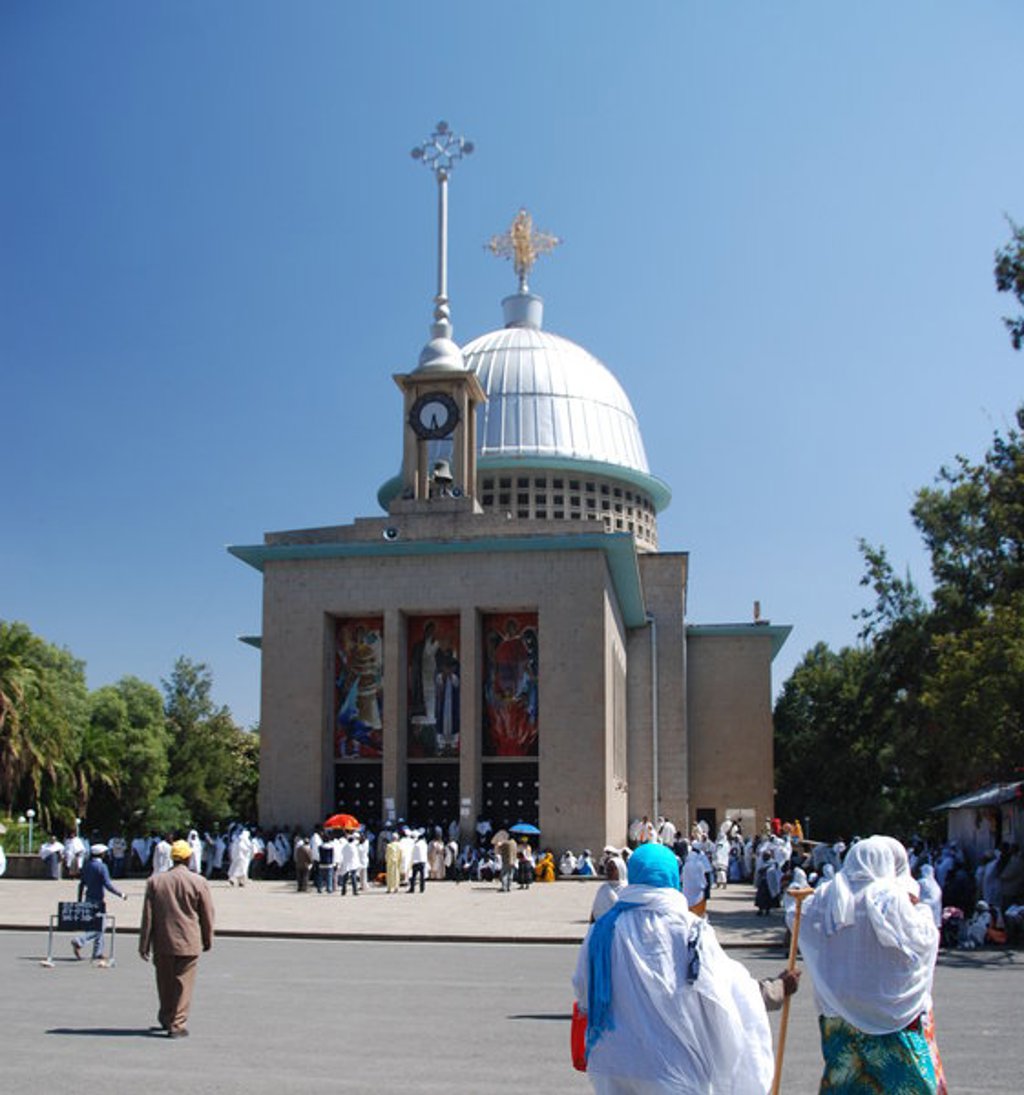 Uitzicht op rotskerk in Ethiopië tijdens een groepsrondreis, met groene heuvels en dorpen in de verte.
