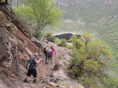 Wandelaars op smal bergpad met uitzicht op groene vallei in Ethiopië.