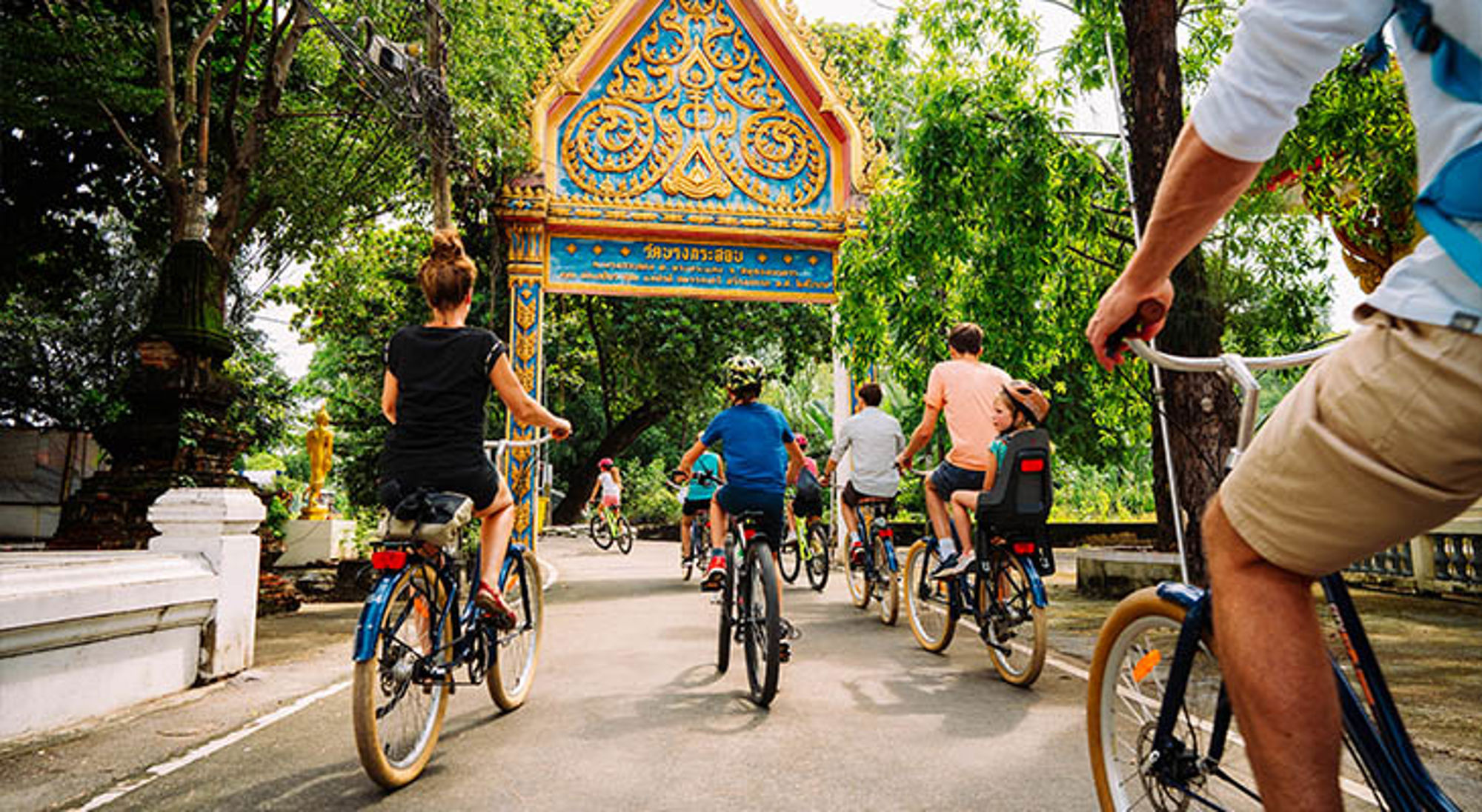 Bangkok Thailand Fietstocht met groep reizigers onder een kleurrijke tempelpoort in Thailand.