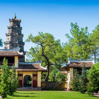 Thiên Mụ-pagode in Hué, Vietnam, met toren en tempelgebouwen tussen groene bomen.