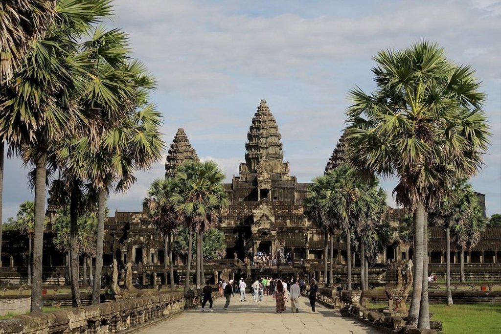 Uitzicht op de Mekong met palmbomen bij zonsondergang tijdens een groepsrondreis Laos en Cambodja.