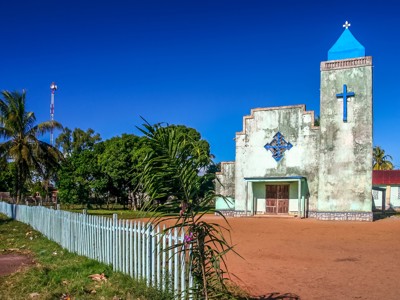 Kerk met blauwe toren en kruis in een dorp op Madagascar, Route Madagascar 19 dagen.