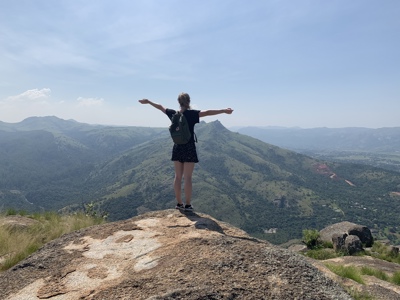 Wandelaar met rugzak op bergtop met uitzicht over de Drakensbergen tijdens route Kaapstad - Johannesburg.