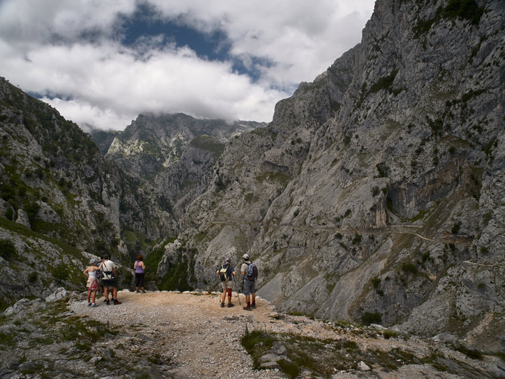 Wandelaars in de Picos de Europa, Spanje, met uitzicht op een ruige bergkloof en rotswanden.