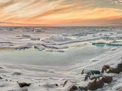 IJsvelden en drijvende ijsschotsen langs de kust bij zonsondergang in Canada en Groenland.