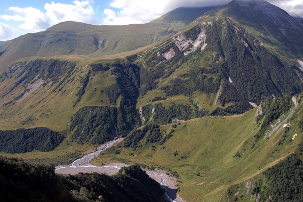 Groene berghellingen en rivierdal in de Kaukasus tijdens een groepsrondreis door Georgië.