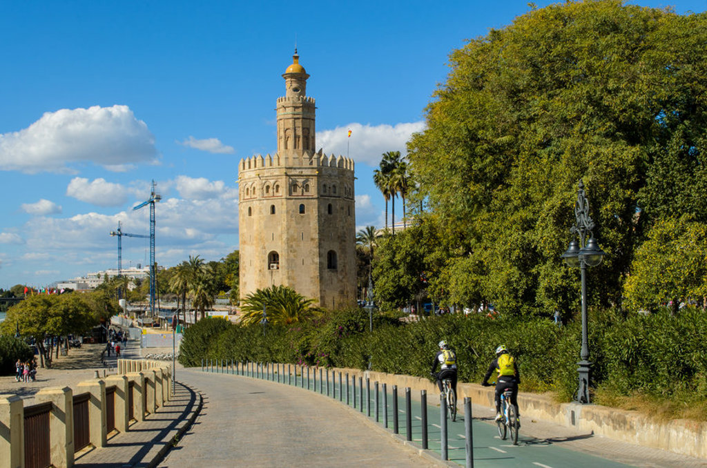 Torre del Oro in Sevilla langs de rivier, met fietsers op het fietspad tijdens de familiereis Spanje & Portugal.