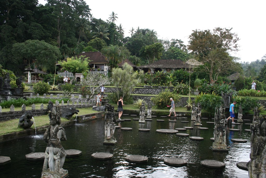 Watertuin op Bali met stenen beelden en stapstenen in een vijver, bezocht tijdens een groepsrondreis.