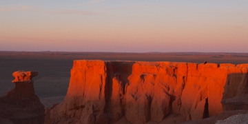Rode kliffen in de Mongoolse Gobiwoestijn bij zonsondergang.